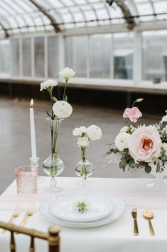 the table is set with white and pink flowers