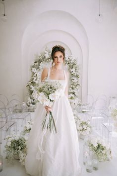 a woman in a wedding dress holding a bouquet