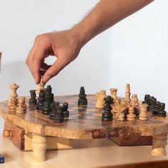 a man is playing chess on a wooden board