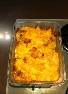 a casserole dish with potatoes and meat in it sitting on a stove top