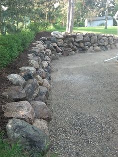 there is a rock wall in the middle of this yard that has been built into it