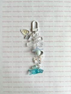 a cell phone charm with charms attached to it's side on a sheet of paper