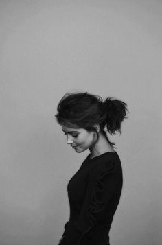 a black and white photo of a woman with her hair in a high pony tail