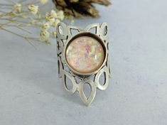 Immerse yourself in a piece of art with this Opalescent Glass Cabochon Ring. At its heart, a glass opal cabochon gleams with a dreamlike charm, embodying the essence of Boho & Hippy styles. Its wide, lattice finish amplifies the allure, making this Big Fantasy Statement Dress Ring a true masterpiece.  Handcrafted with precision, the Gorgeous Fancy Hippy Ring Women is a testament to impeccable craftsmanship. Plated in antique silver and weighing a substantial 18 gm, this Handcrafted Artful Wide R Hippie Rings, Silver Wrap Ring, Wide Ring, Wrap Ring, Statement Dress, Cabochon Ring, Wide Rings, Dress Rings, Ring Women