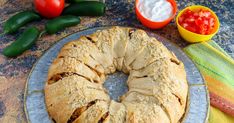 a bundt cake sitting on top of a plate next to some vegetables and dip