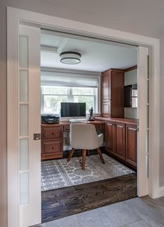 an open door leading to a home office with a desk and chair in the corner