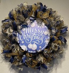 a christmas wreath hanging on the wall next to a sign that reads, merry christmas