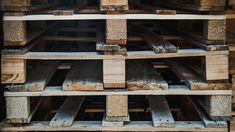 several stacks of wooden pallets stacked on top of each other in a storage room