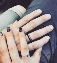 two people with black and white nail polish holding each other's hands in their arms