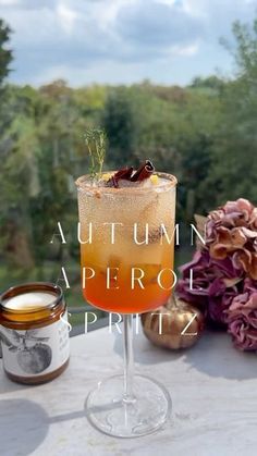 an autumn aperoli drink on a table with flowers