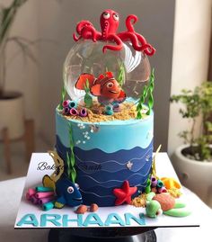 a birthday cake decorated with an ocean scene and under the sea animals in a fish bowl