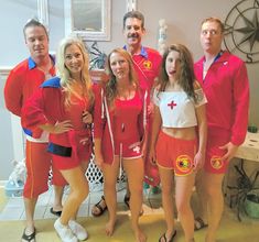 a group of people in red and white outfits posing for a photo with each other