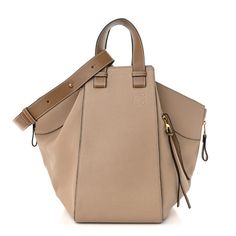 This is an authentic LOEWE Calfskin Medium Hammock Shoulder Bag in Sand and Mink.This chic and lovely tote is crafted of luxuriously soft calfskin leather in beige with brown leather trim. This handbag features a unique one piece reinforced design with leather handles and an optional adjustable shoulder strap. The top opens to a spacious beige fabric interior with small patch pockets. Designer Beige Calf Leather Bag, Luxury Beige Leather Satchel, Luxury Taupe Leather Bag, Beige Calf Leather Satchel Shoulder Bag, Beige Calf Leather Top Handle Shoulder Bag, Beige Calf Leather Shoulder Satchel, Beige Calf Leather Satchel, Luxury Taupe Leather Shoulder Bag, Everyday Taupe Leather Bucket Bag