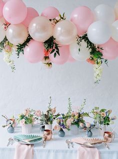 an instagram page with balloons and flowers hanging from it's ceiling above a table