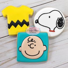 three decorated cookies in the shape of peanuts, charlie brown and t - shirt shapes