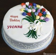 a birthday cake with white frosting and colorful flowers on the top that says, happy birthday dear lily