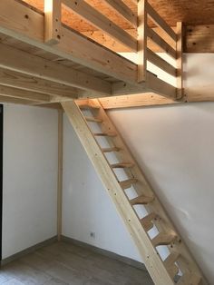 an unfinished loft with stairs leading up to the second floor