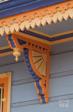 an orange and blue building with a clock on it's side window sill