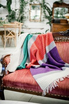 a colorful blanket sitting on top of a red couch next to a wooden chair with text overlay that reads, furls fibers