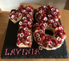 there is a cake with strawberries and flowers on the top that says lavinia