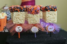 halloween treats are arranged on top of each other in front of a table with decorations