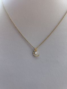 This dainty necklace is beautiful in its simplicity. D E T A I L S🌙 *It features a Korean-made gold plated hammered moon charm measuring 10mm x 8.5mm. *And a small crystal pendant. *It is suspended from a delicate 14k non tarnish stainless steel chain. *Length: Choose the length you prefer from the drop down menu. Use the length chart as a reference.  C A R E * T I P :  To keep your necklace in good condition please avoid contact with water, perfume and body lotion and remove when exercising or Dainty Crescent Moon Charm Necklace, Delicate 14k Gold Necklaces With Moon Charm, Delicate 14k Gold Necklace With Moon Charm, Dainty Yellow Gold Moon Phase Necklace, Delicate Moon Charm Necklaces, Dainty Moon Charm Pendant Necklace, Dainty Crescent Yellow Gold Charm Necklaces, Dainty Yellow Gold Crescent Charm Necklaces, Dainty Yellow Gold Moon Necklace