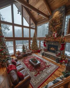 a living room filled with furniture and christmas trees in front of large windows covered in snow