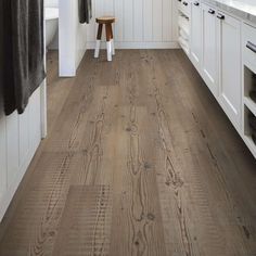 a kitchen with white cabinets and wood floors