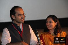 a man standing next to a woman holding a microphone