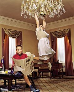 a man and woman are sitting on the floor with a chandelier above them