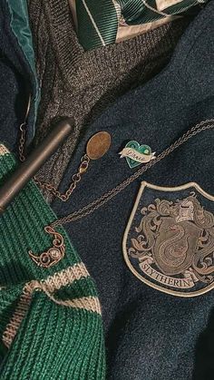 a green tie and blue jacket with badges on it's lapel, sitting next to other clothing items