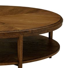 a round wooden table with two shelves on the bottom and one shelf below it that is holding a coffee table