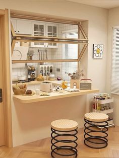 two stools sitting in front of a counter with food on it and shelves above