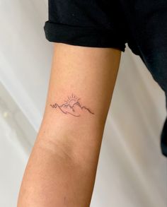 a woman's arm with a small tattoo on the left side of her arm