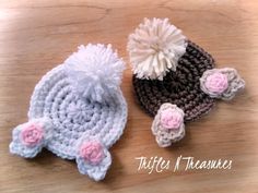 two crocheted hats sitting on top of a wooden table