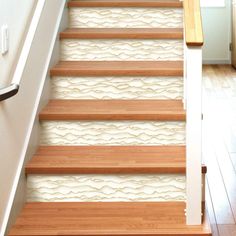 the stairs are decorated with white wallpaper and wooden handrails, along with wood flooring