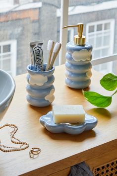 soap, toothpaste and other bathroom items on a table in front of a window