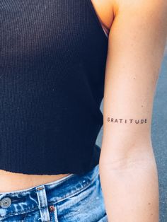 a woman with a tattoo on her arm that reads,'great tude '