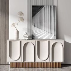 a white sideboard with two vases and a mirror on the wall next to it