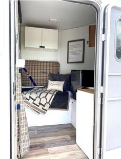 the inside of a camper with couches and pillows on it's side