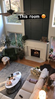 a living room filled with furniture and a fire place next to a large window that reads, this room