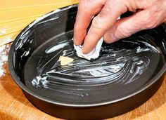 a person wiping down something in a black bowl