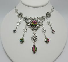 "This is a new handmade necklace. It is made with antiqued silver plated filigrees, accented with high quality RAINBOW TOPAZ glass jewels/rhinestones that sparkle like crystals. Decorated portion is 6 1/2\" wide and 3 1/4\" tall in the center. Necklace is adjustable 15-18\" with a lobster clasp and chain extender. If you would like a different length, please send us a message. Matching earrings and headpiece are listed in our store." Silver Fantasy Jewelry For Festivals, Steampunk Silver Jewelry For Weddings, Medieval Steampunk, Steampunk Goth, Antique Silver Necklace, Rainbow Topaz, Choker Pendant, Chain Extenders, Crystal Ab