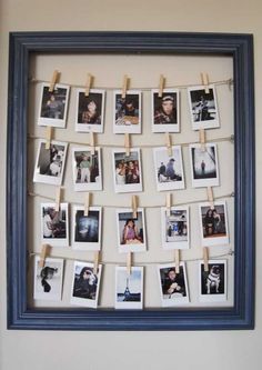 an old photo frame with clothes pins attached to it and pictures hanging on the clothes pegs