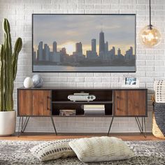 a living room with a large television on the wall and a plant in front of it