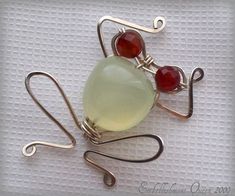 a brooch with two red glass beads attached to it's back and silver wire