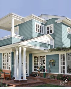 a blue house with white trim and columns