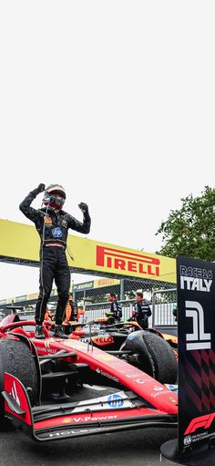 a man standing on top of a racing car