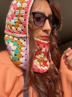 a woman wearing sunglasses and a crocheted hat