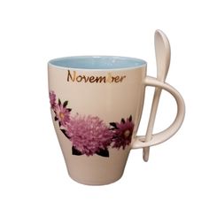 a coffee cup with a spoon sticking out of it's side that says november